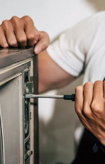 Werkstatt für TV und Audio, Techniker öffnet die Rückwand eines alten Fernsehers